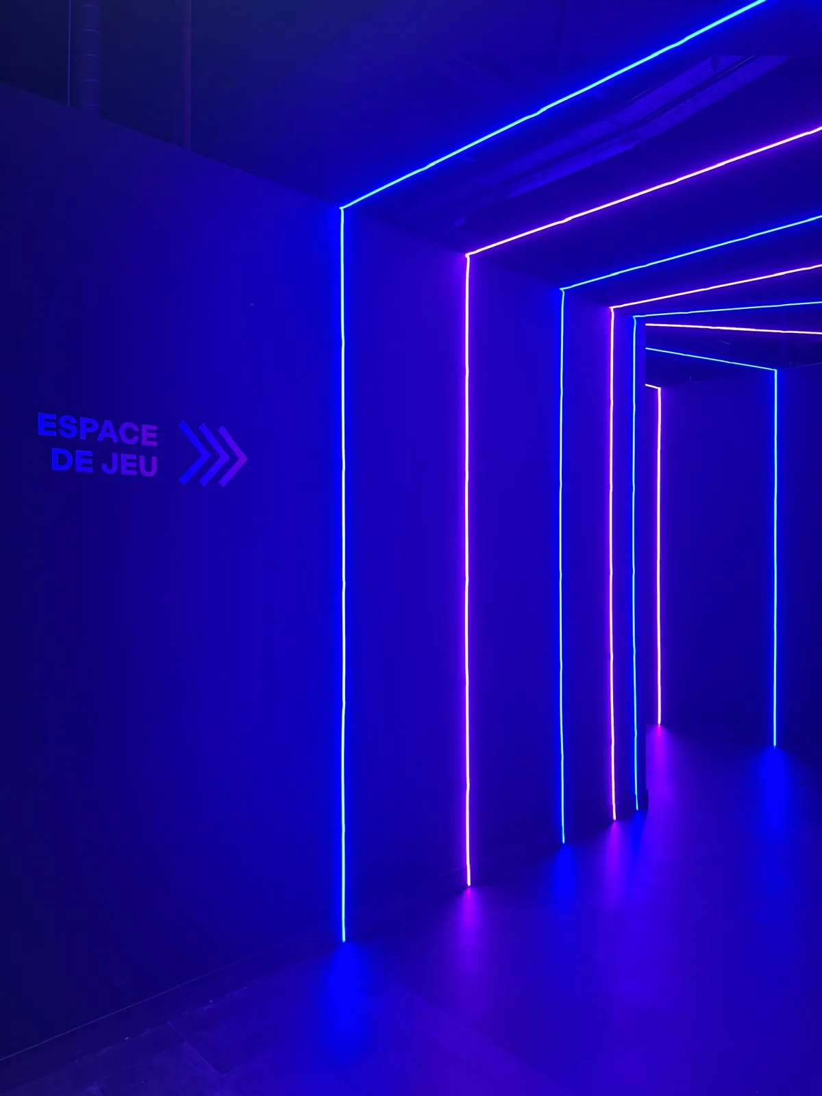 Couloir d'accès aux espaces de jeu éclairé par bandes LED colorées
